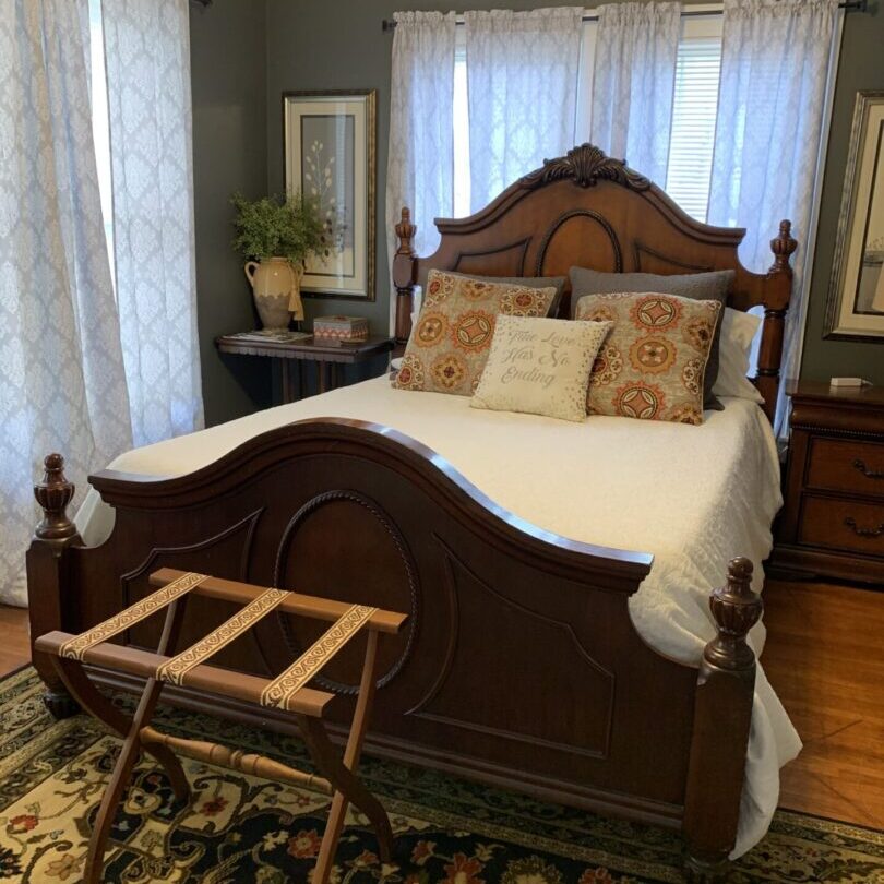 A bed with white sheets and pillows on it.